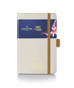 stijlvolle en moeiteloos herkenbare kleine hardcover notitieboekje van Sheaffer is perfect om gedachten vast te leggen wanneer de inspiratie toeslaat. Het is afgewerkt in een beige tint met een reliëfafbeelding van de Eiffeltoren en het monogram van EMILY  IN PARIS op de omslag